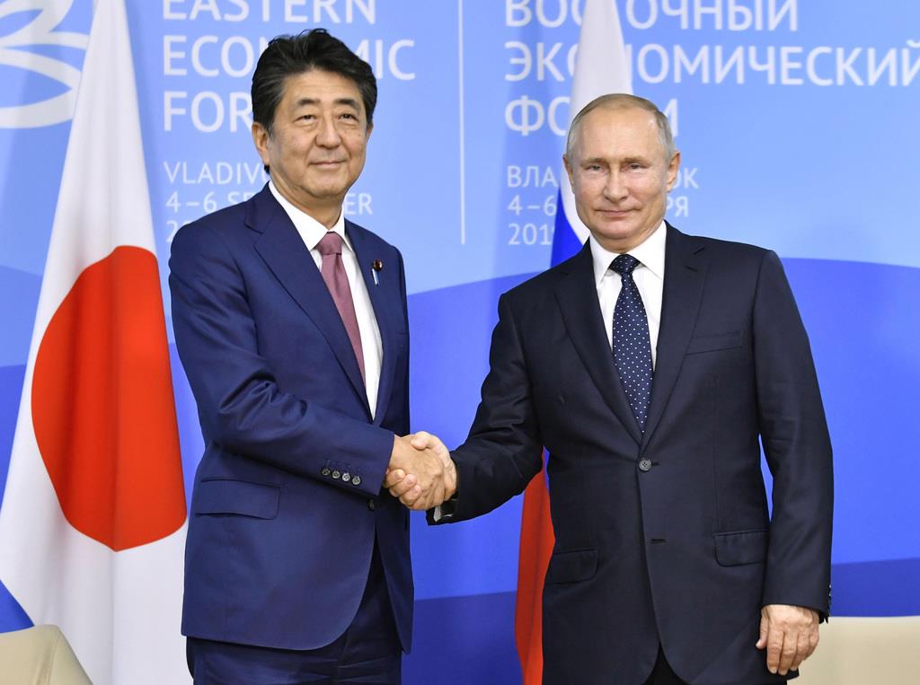 会談前、握手するロシアのプーチン大統領(右)と安倍首相=5日、ロシア・ウラジオストク(共同)