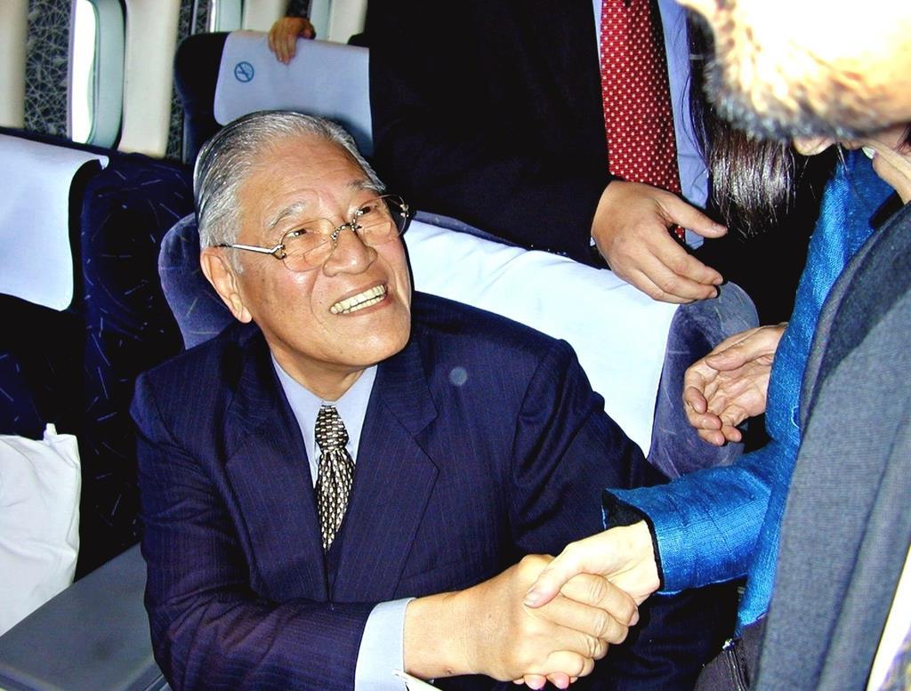 関西空港へ向かう航空機内で、同行者と握手する李登輝氏=2001年04月22日