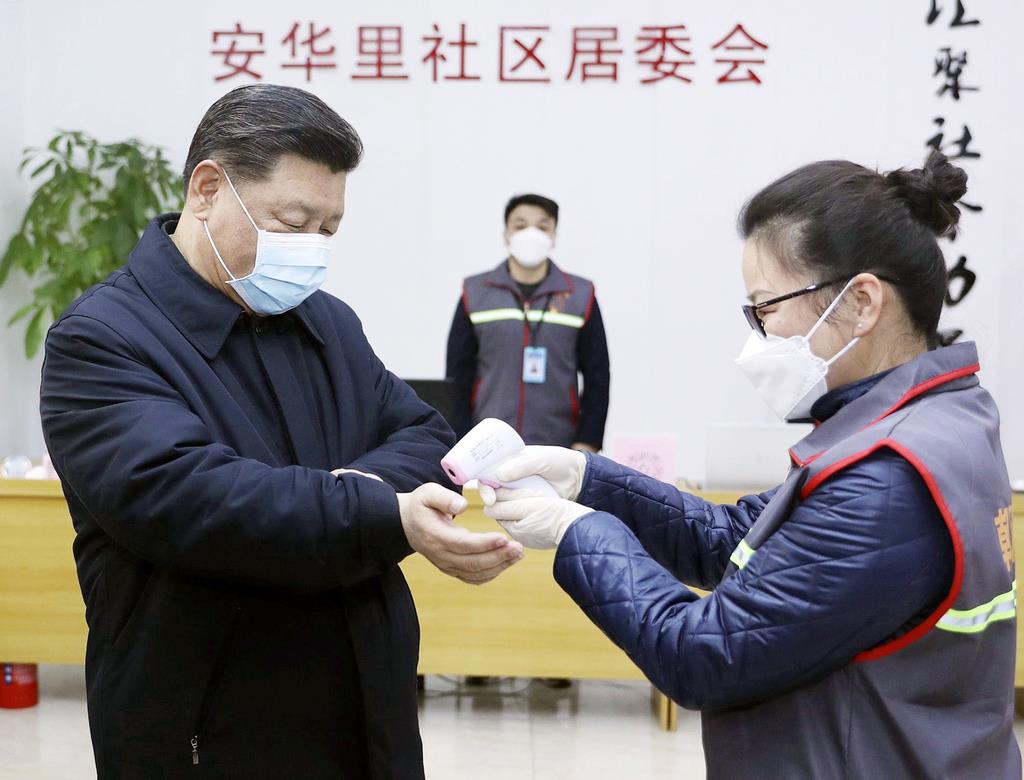 北京市内の施設を視察し、マスク姿で体温検査を受ける中国の習近平国家主席(左)=2月10日(新華社=共同)