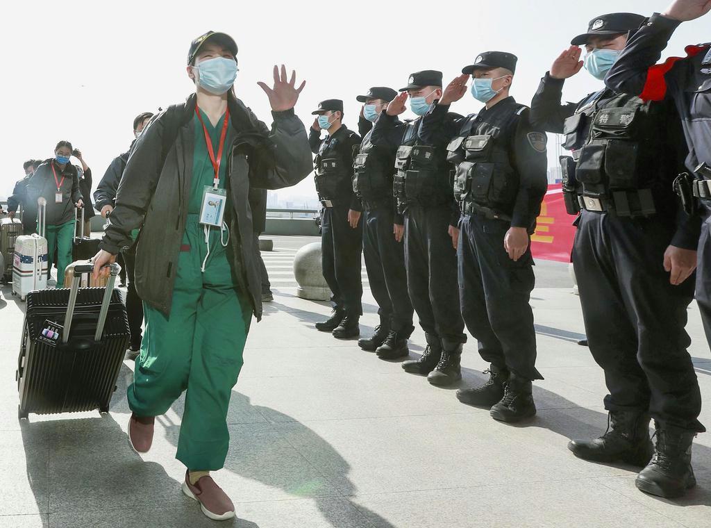 患者の減少を受け、中国・武漢を撤収する医療従事者(左)ら=3月17日(共同)