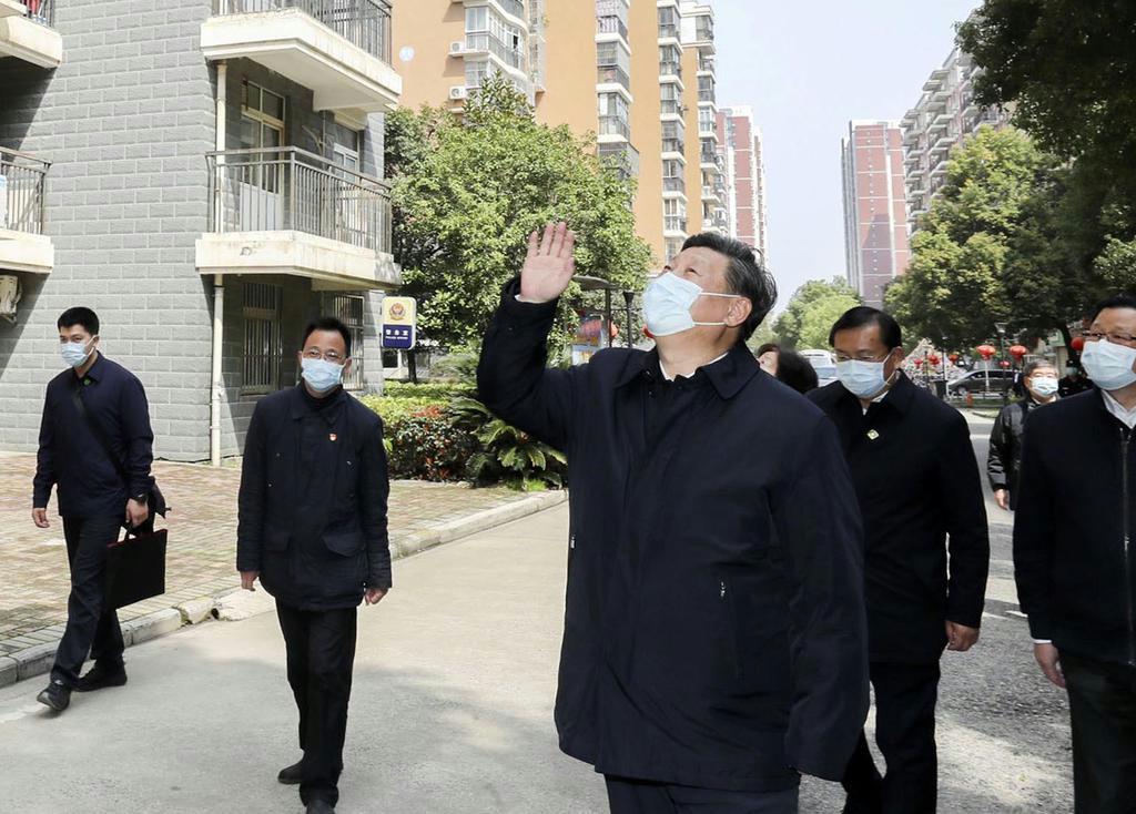 中国・武漢市内を視察し、住民に向かって手を振る習近平国家主席(手前)=3月10日(新華社=共同)