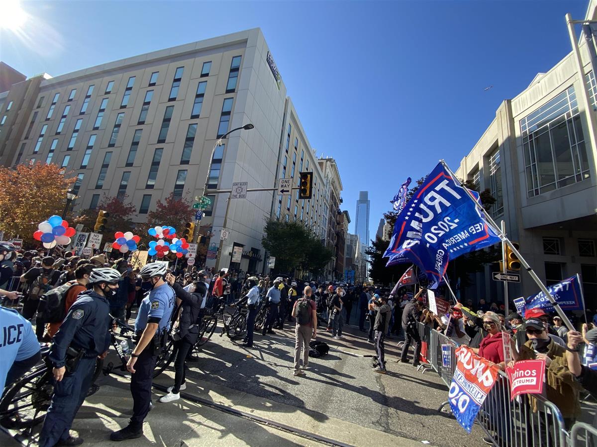 米大統領選の開票が続く東部ペンシルベニア州フィラデルフィアの開票所前で、警官に囲まれてバイデン氏の支持者らと対峙するトランプ氏支持者ら(右)=6日(上塚真由撮影)