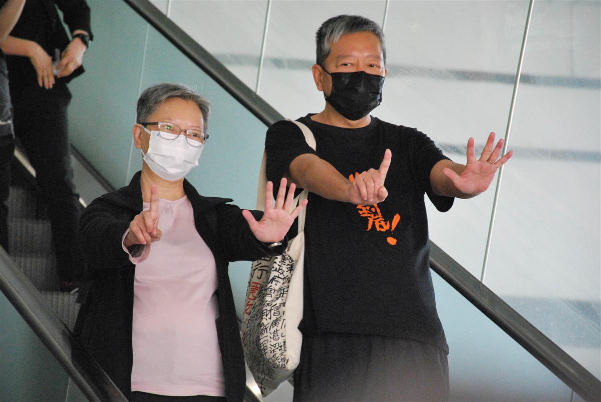 1日、香港の裁判所で、有罪判決後に法廷を出て、政府への抗議を示すジェスチャーをする民主派団体「香港市民愛国民主運動支援連合会」の李卓人主席(右)(共同)