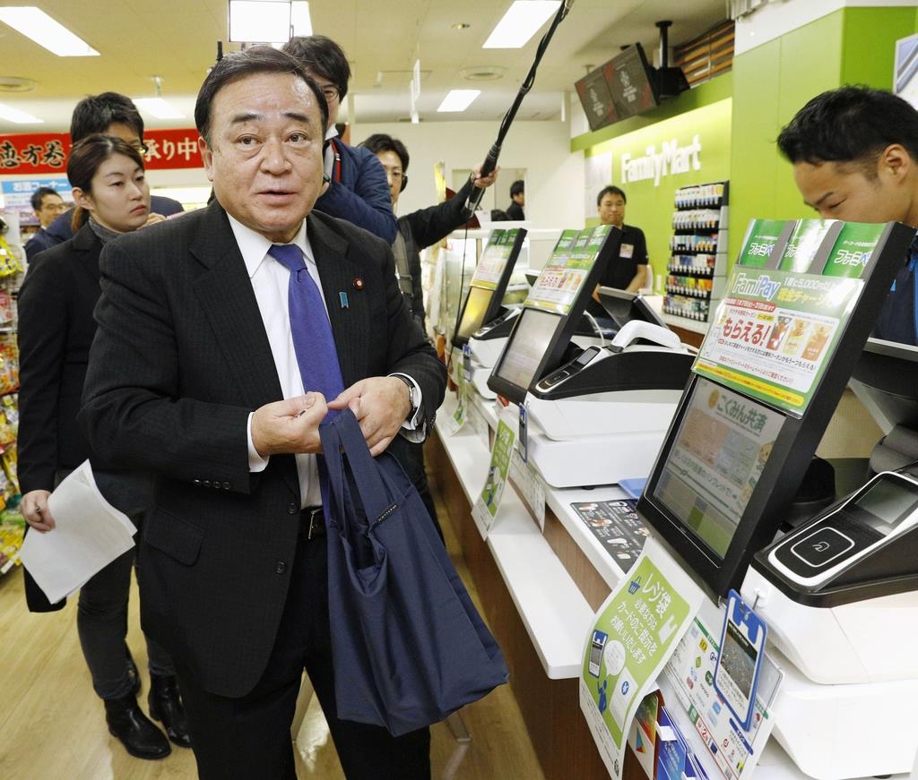 レジ袋有料義務化に向けた実験で、持参したエコバッグを手にする梶山弘志経済産業相=1月、東京都千代田区