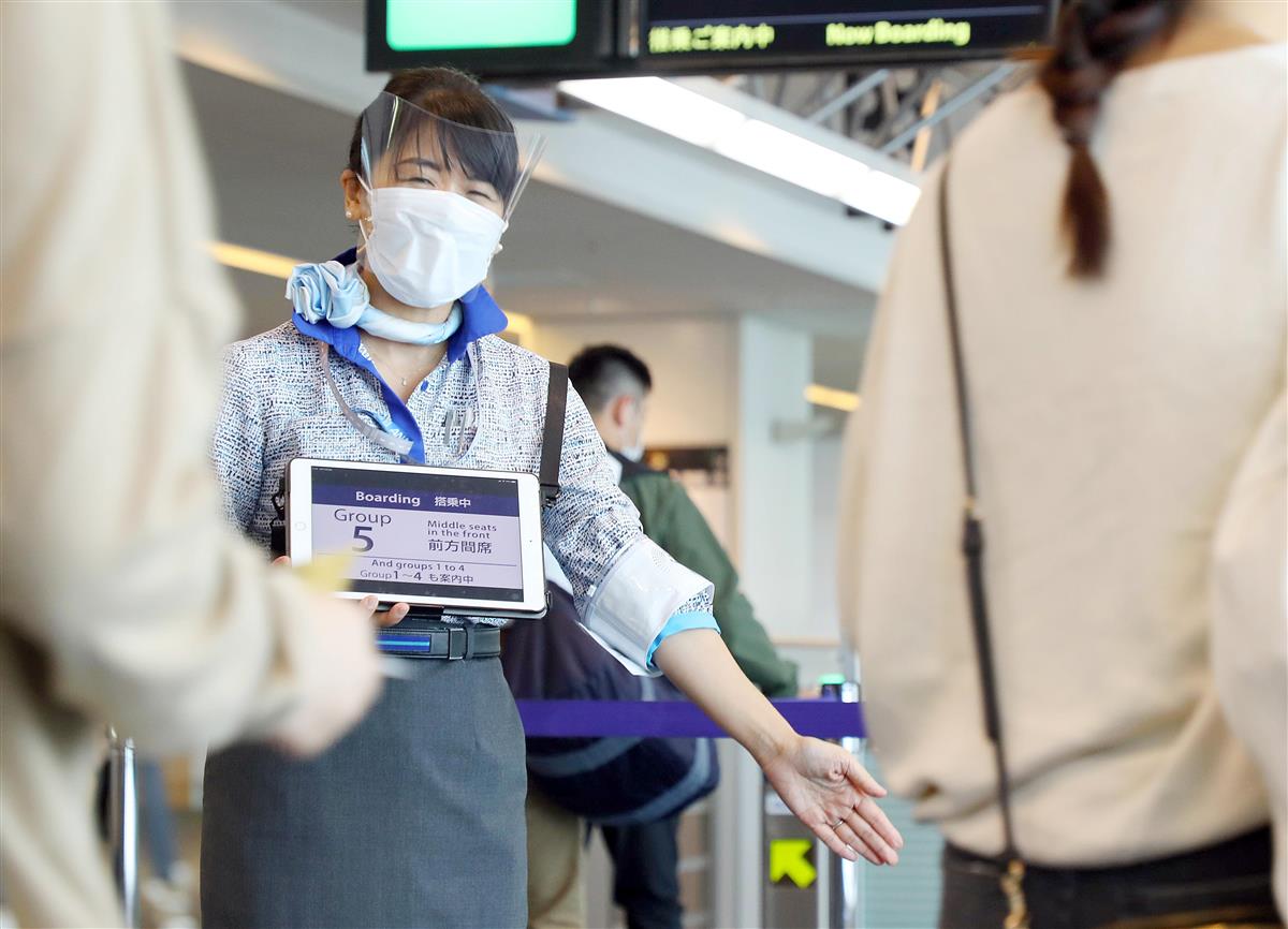 新型コロナウイルス感染防止のため分散搭乗を案内する全日空の職員=6月19日、羽田空港