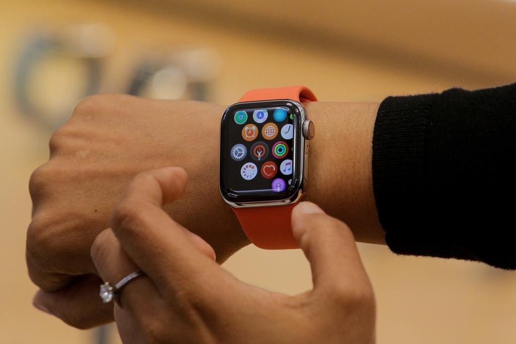 米ニューヨークの5番街のアップルストアで、従業員によってお披露目されたアップルウオッチの最新型「シリーズ5」=2019年9月19日(ロイター)