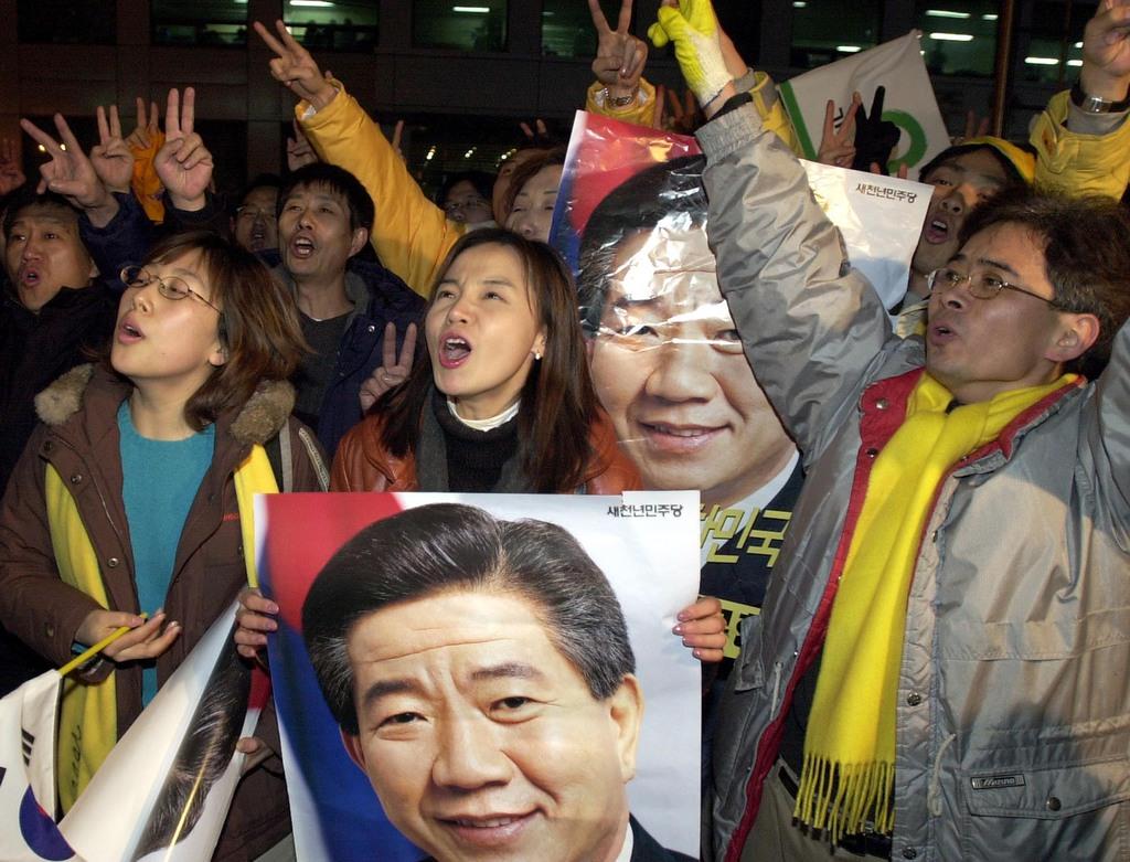 盧武鉉候補の当選を願ってソウルの新千年民主党本部前に集まる熱烈な支持者たち ＝２００２年１２月（ＡＰ）