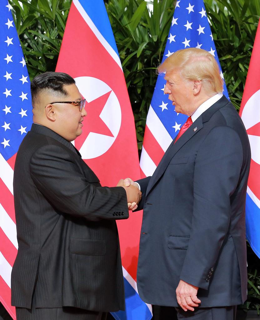 会談の冒頭、握手する北朝鮮の金正恩朝鮮労働党委員長(左)とトランプ米大統領=6月、シンガポール(朝鮮中央通信撮影・共同)