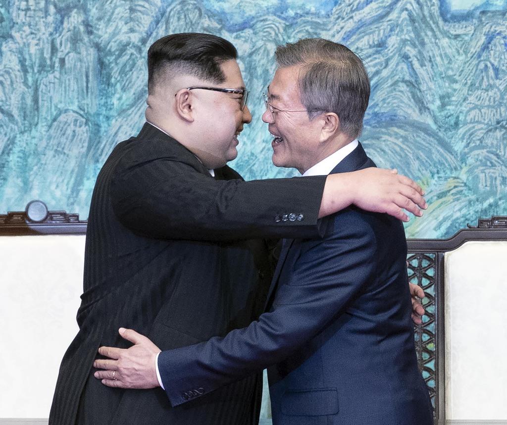 「板門店宣言」に署名し、韓国の文在寅大統領（右）と抱擁する北朝鮮の金正恩朝鮮労働党委員長＝２０１８年４月２７日午後、板門店の韓国側施設「平和の家」（韓国共同写真記者団撮影）