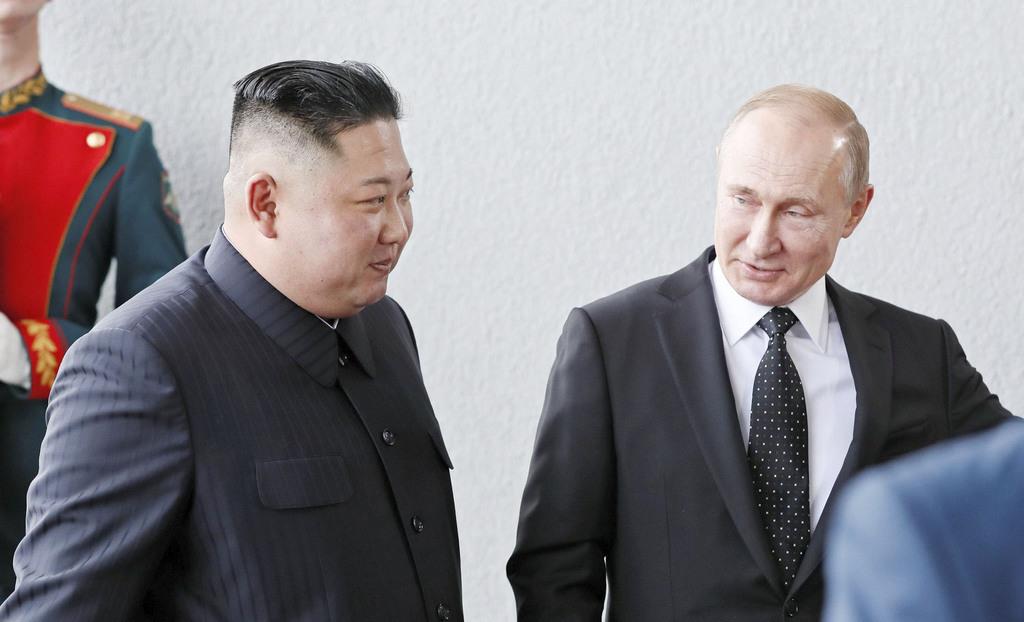 ロシアのプーチン大統領(右)の出迎えを受ける北朝鮮の金正恩朝鮮労働党委員長=25日、ロシア・ルースキー島(ロイター)