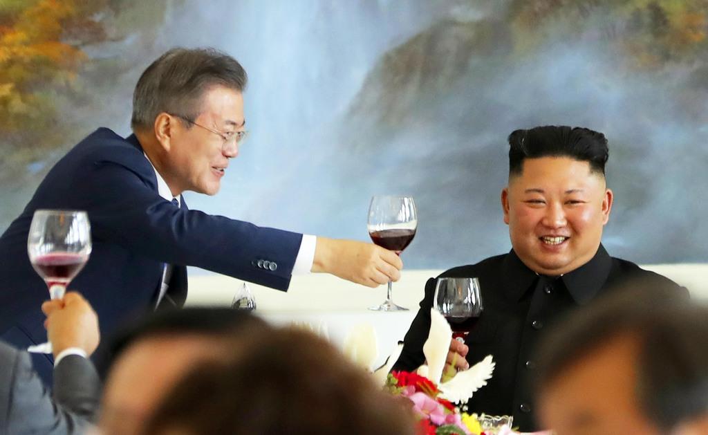 北朝鮮・平壌の老舗冷麺店「玉流館」で開かれた昼食会で乾杯する、韓国の文在寅大統領(左)と北朝鮮の金正恩朝鮮労働党委員長(中央)=2018年9月19日(平壌写真共同取材団)