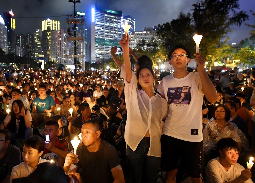 天安門事件から３０年を迎え、ろうそくを手に犠牲者を悼む人たち＝４日、香港のビクトリア公園（共同）