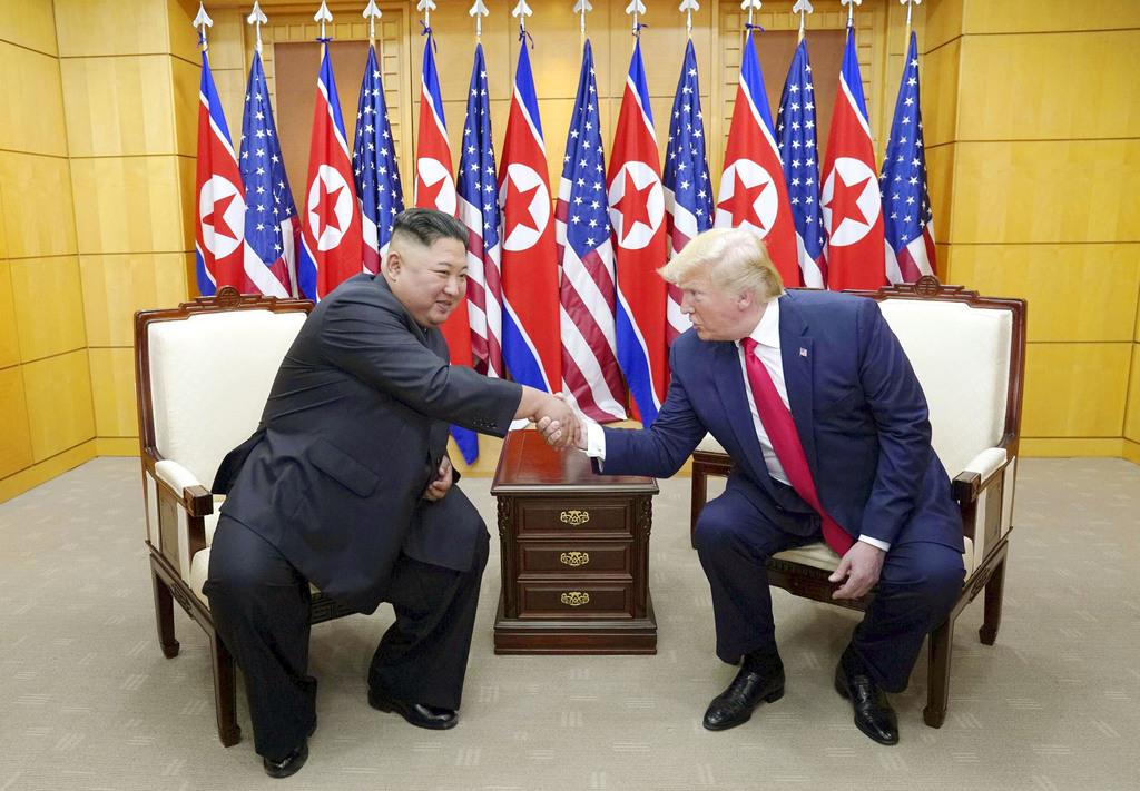 板門店の韓国側施設で握手する北朝鮮の金正恩朝鮮労働党委員長(左)とトランプ米大統領=30日(ロイター)