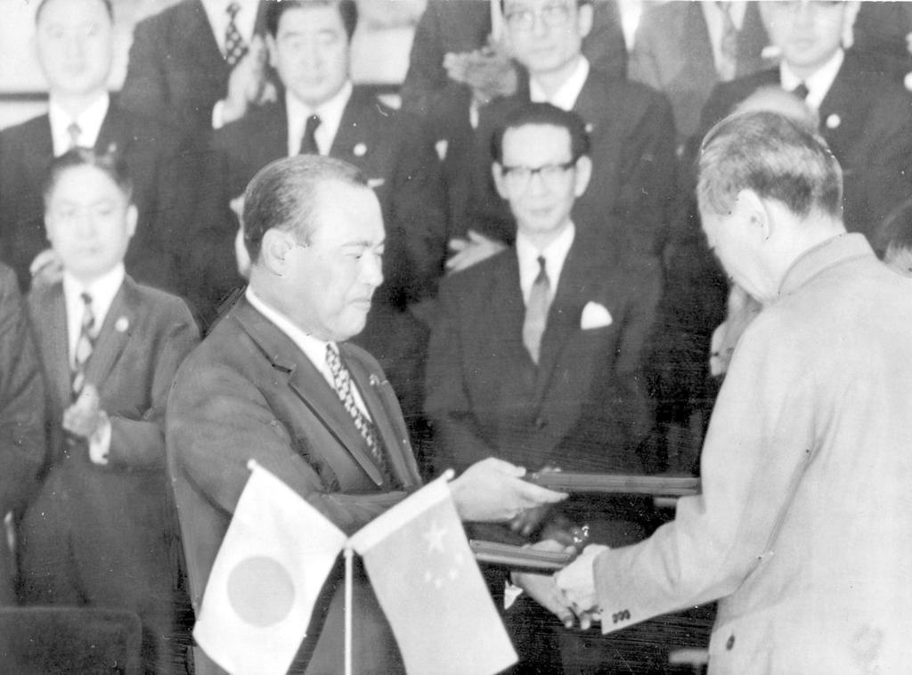 1972(昭和47)年9月29日、中国・北京で日中共同声明の調印文書を交換する田中角栄首相(手前左)と中国の周恩来首相