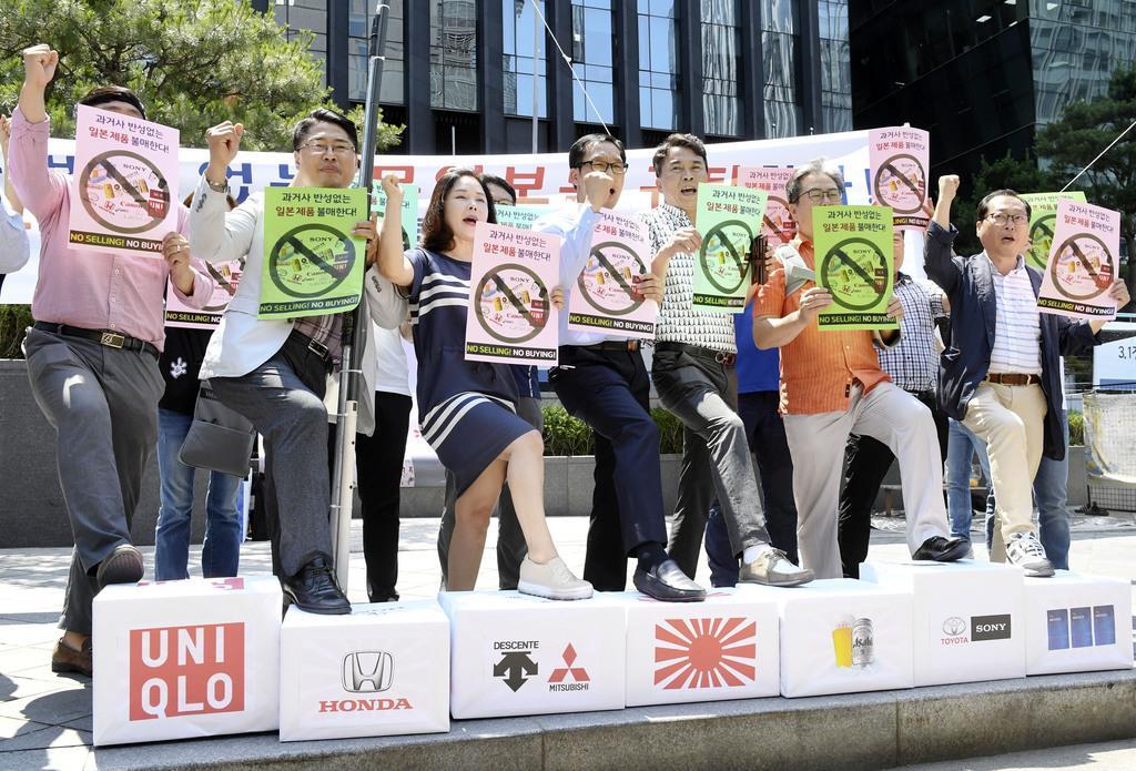 5日、ソウルで日本企業のロゴマークが描かれた箱を踏みつぶす韓国の中小企業経営者ら(共同)