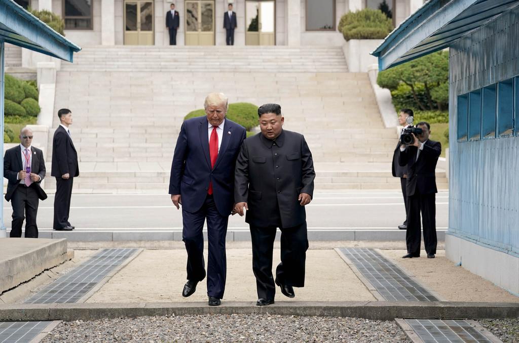 南北軍事境界線を越えて北朝鮮側から韓国側に入るトランプ米大統領(左)と北朝鮮の金正恩朝鮮労働党委員長=30日、板門店(ロイター)