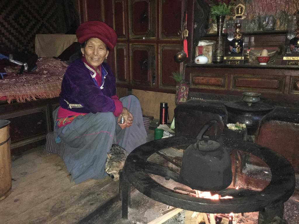 モソ人の伝統家屋で暮らすディンヤさんは一家の主だ＝中国雲南省ジャシ村（藤本欣也撮影）