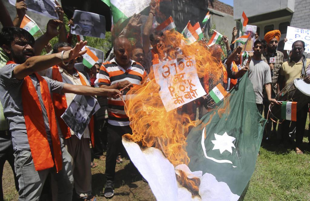８日、インド北部ジャム・カシミール州ジャムで、パキスタンの国旗を燃やす人々（ＡＰ）