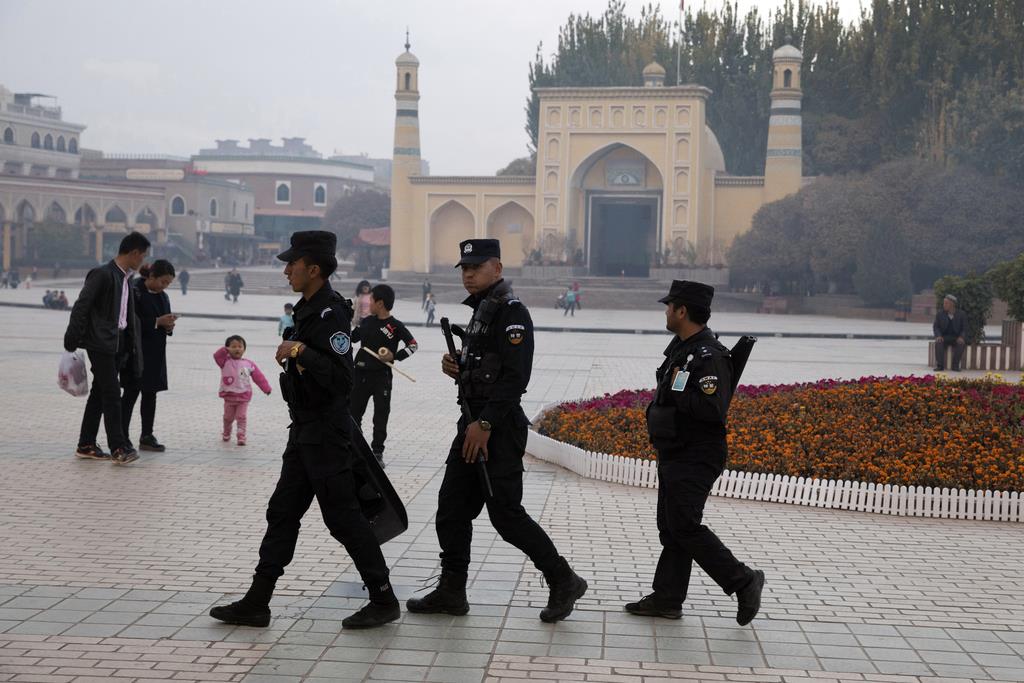 中国・新疆ウイグル自治区カシュガルで、モスク前の広場をパトロールする治安部隊員=2017年11月(AP)