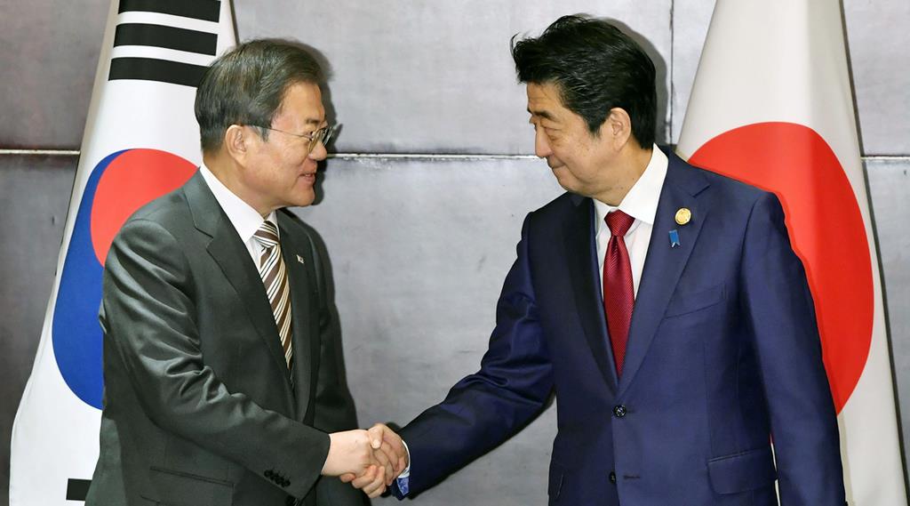 日韓首脳会談を前に握手を交わす韓国の文在寅大統領(左)と安倍首相=12月24日、中国・成都(共同)