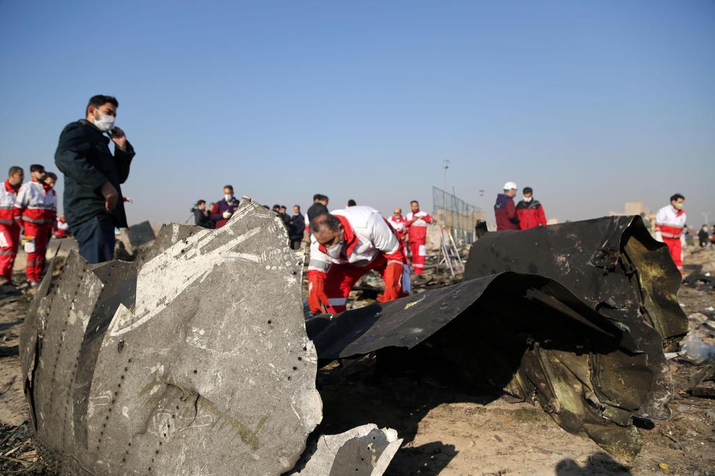 ８日、イランの首都テヘランで、墜落したウクライナ旅客機の残骸を調べる当局者ら（ゲッティ＝共同）