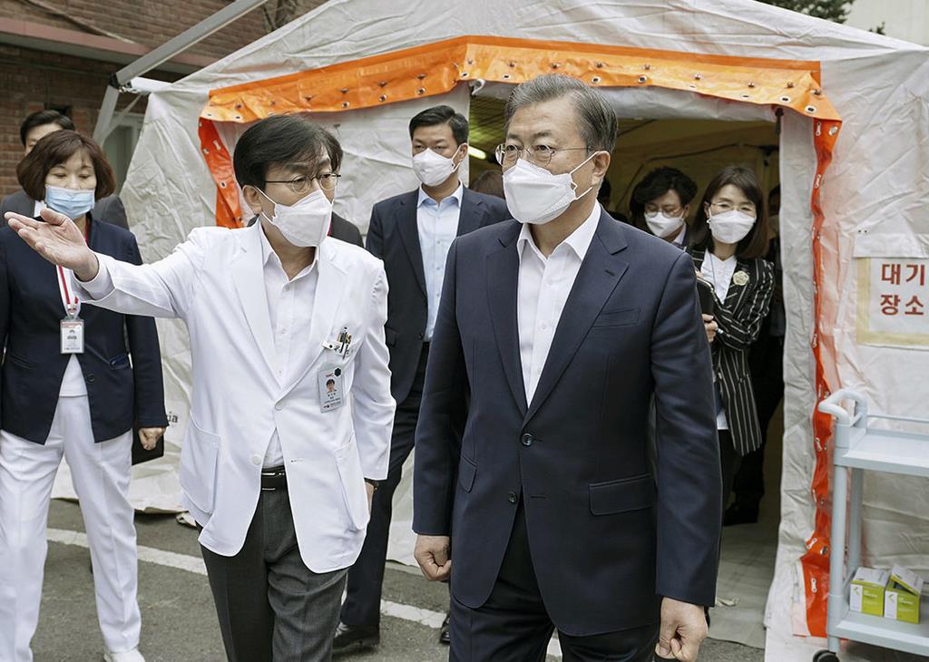 新型コロナウイルスの感染者を治療中の病院を視察する韓国の文在寅大統領(手前右)=1月28日、ソウル(大統領府提供・共同)