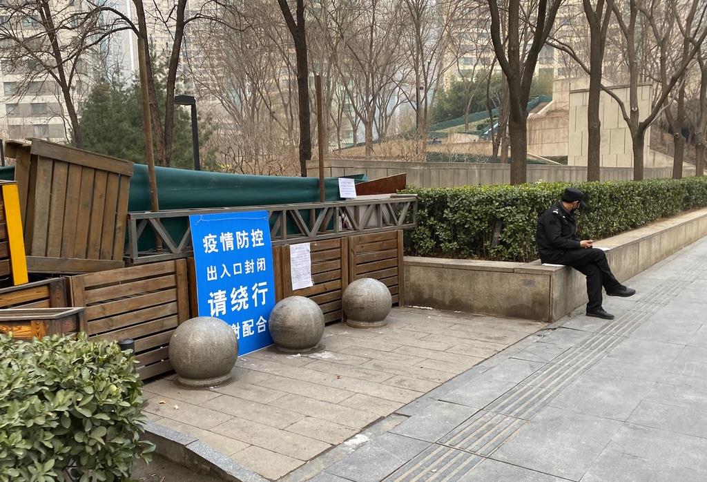 12日、北京市内の集合住宅の通路にもうけられたバリケード。部外者の出入りなどを管理するため、正面入り口以外の通路がふさがれていた(三塚聖平撮影)