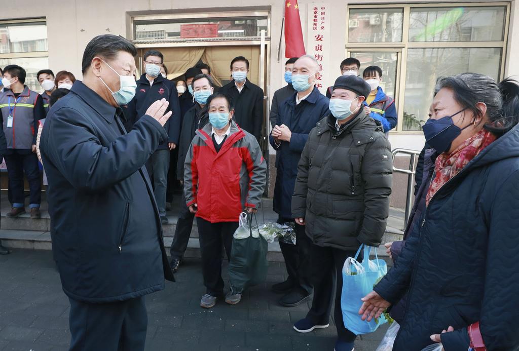 北京市内の「社区」を訪れ、マスクを着けて住民と話す中国の習近平国家主席（左手前）＝１０日（新華社＝共同）