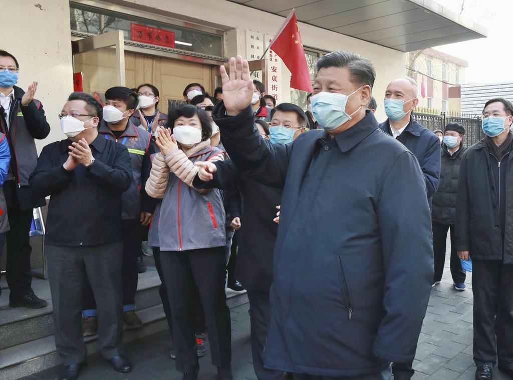 北京市内を視察し、マスク姿で手を振る中国の習近平国家主席(右手前)=2月10日(新華社=共同)