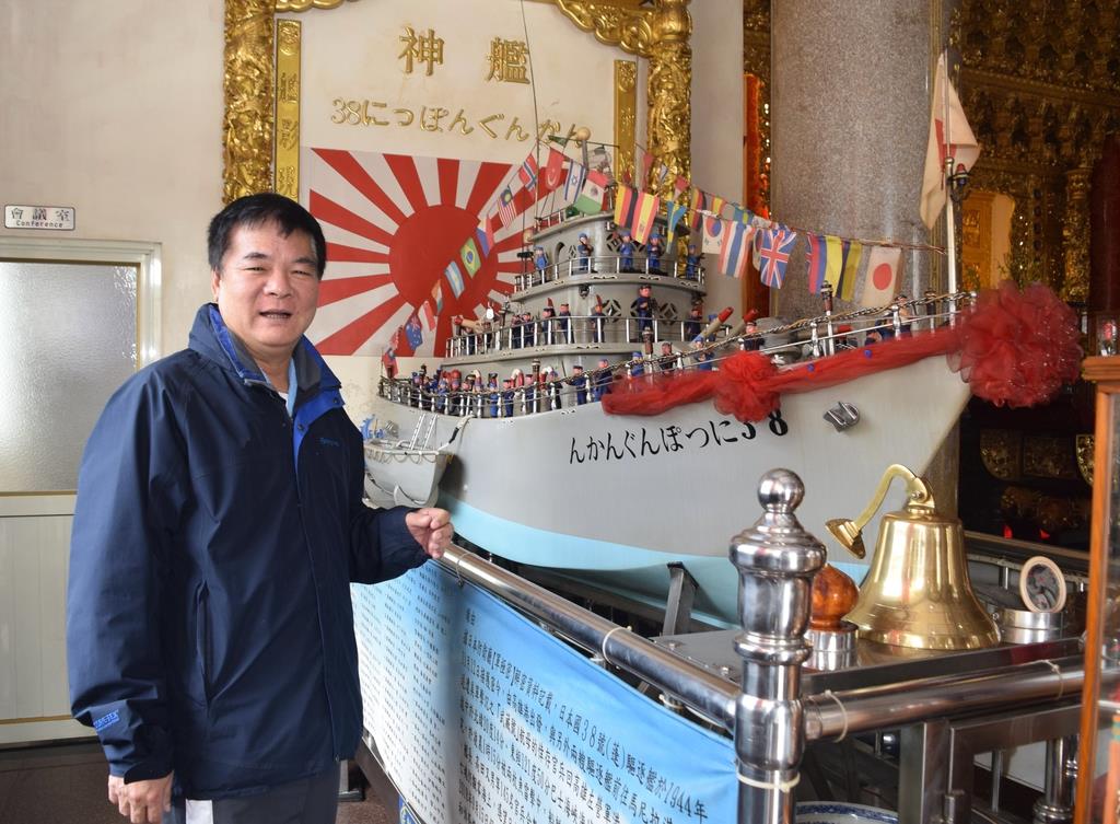 台湾南部・高雄市の廟「紅毛港保安堂」で、「神艦」のそばに立つ廟の張吉雄主任委員=2月18日(田中靖人撮影)