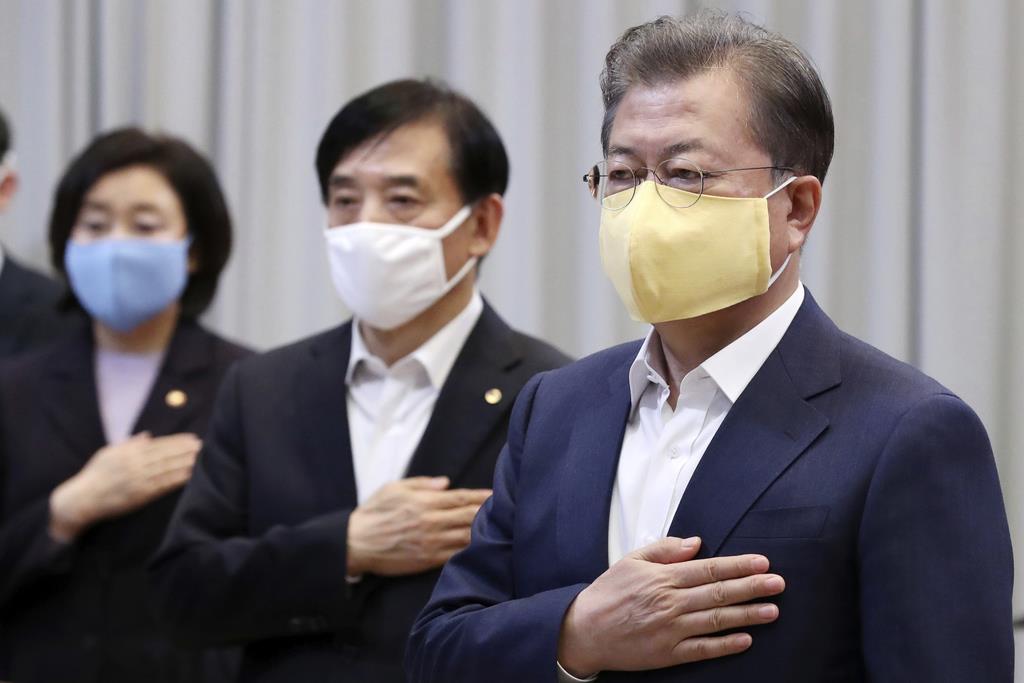 マスクをつけて韓国大統領府での会議に出席する文在寅大統領(右)ら=3月19日、ソウル(AP)