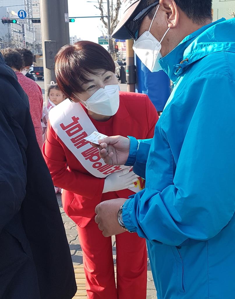 韓国ソウル市内の街頭で有権者らにあいさつする「南北統一党」の韓美玉候補(左)=8日、桜井紀雄撮影