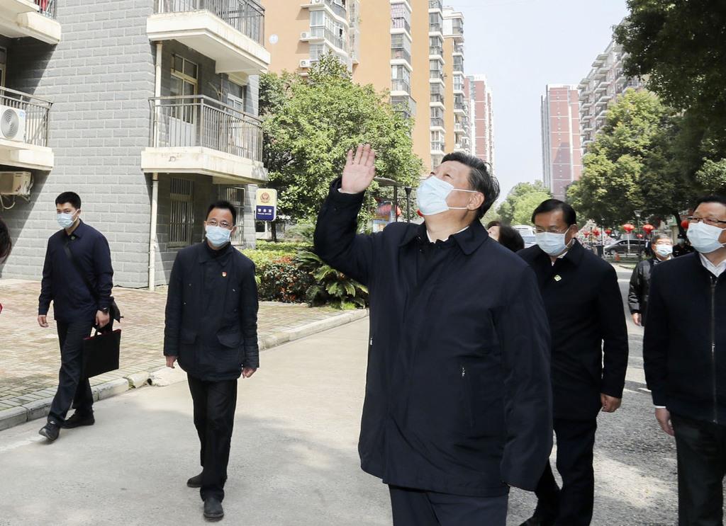 中国・武漢市内を視察し、住民に向かって手を振る習近平国家主席(手前)(新華社=共同)