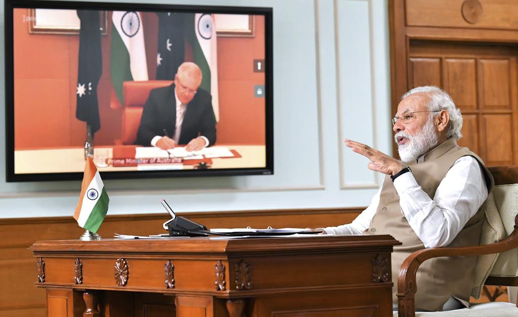 豪州のモリソン首相とオンライン会談をするインドのモディ首相=4日、ニューデリー(インド政府広報局提供、AP)