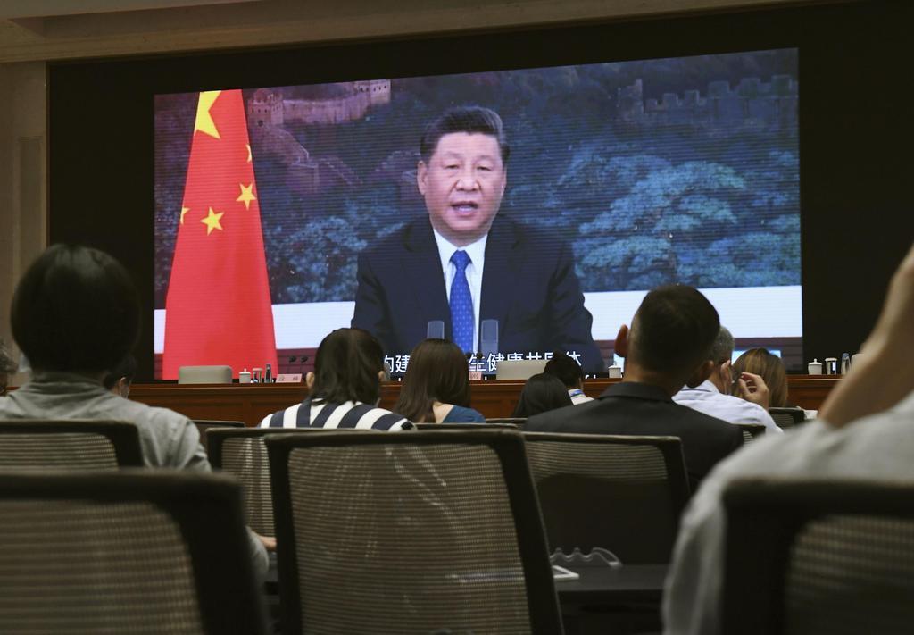 記者会見場で習近平国家主席の映像を見る報道関係者ら=北京(共同)