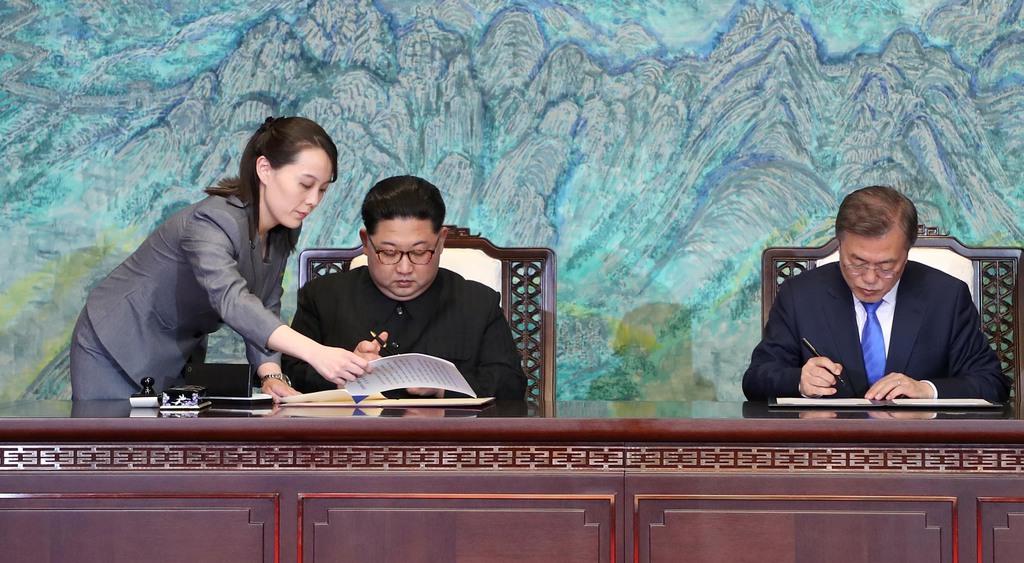 共同宣言に署名する（左２人目から）北朝鮮の金正恩朝鮮労働党委員長、韓国の文在寅大統領。左端は金与正党第１副部長＝２０１８年４月２７日、板門店の韓国側施設「平和の家」（韓国共同写真記者団撮影）