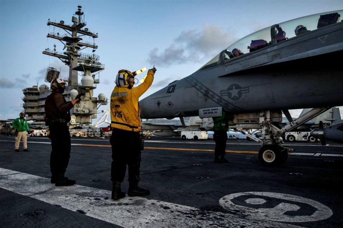 米原子力空母ロナルド・レーガンの艦上で、FA18戦闘攻撃機の飛行前点検を行う兵士=6月30日、フィリピン海(米国防総省提供・共同)