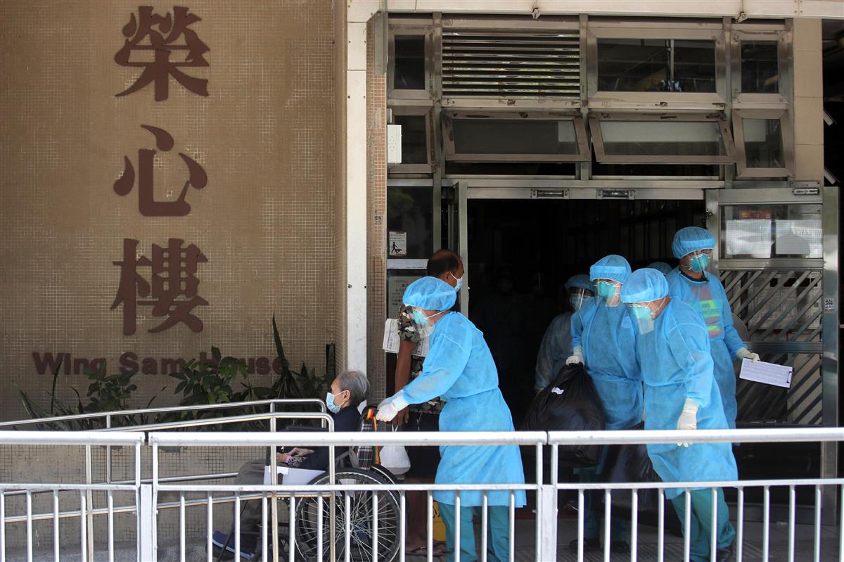 24日、香港の高齢者施設で、職員の新型コロナウイルス感染を受け避難する入所者。新型コロナ感染拡大に伴い、立法会選の延期論も浮上する(AP)