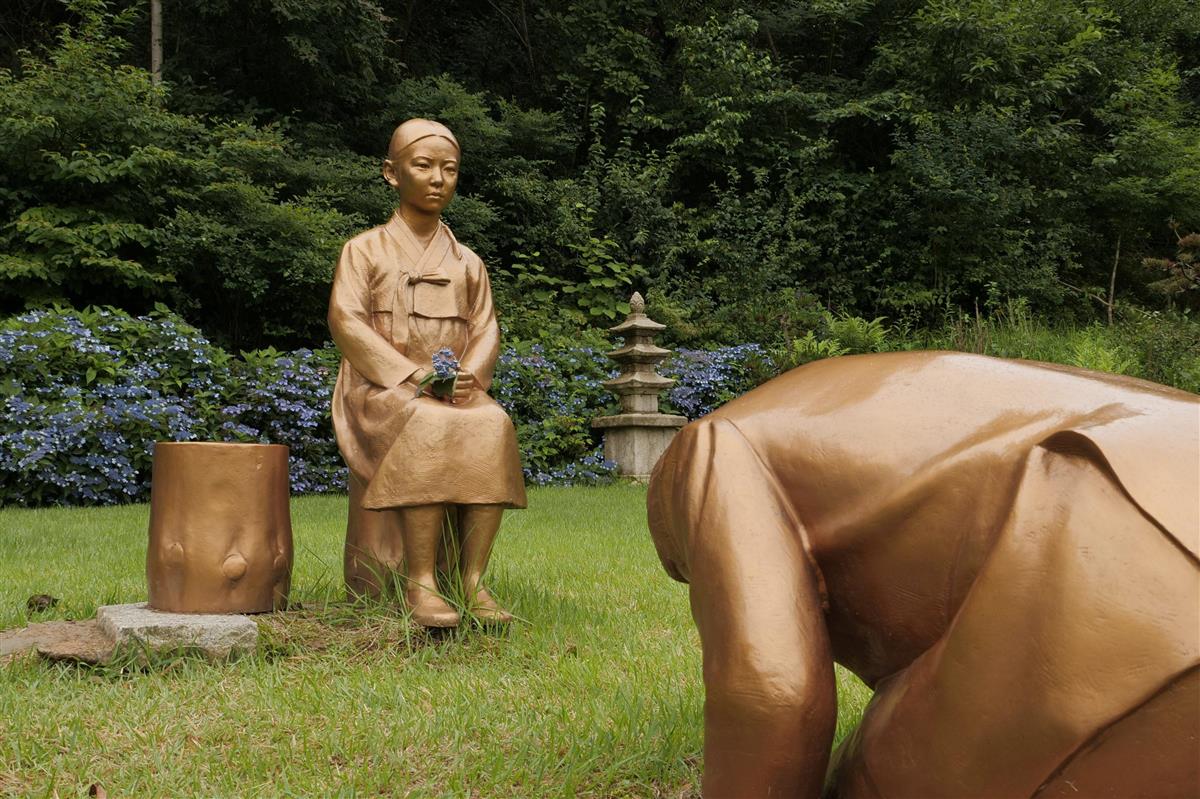 韓国・平昌にある「韓国自生植物園」に設置された慰安婦像（左）と当初、安倍晋三首相を模したとされた像＝６月２８日（ロイター）