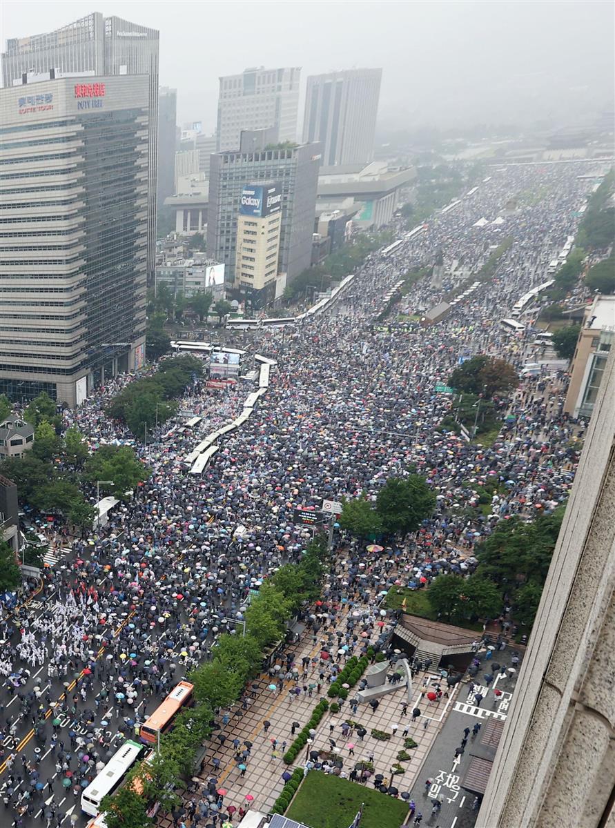 15日、ソウル中心部で開かれた韓国の文在寅政権を批判する集会に参加する市民ら(聯合=共同)