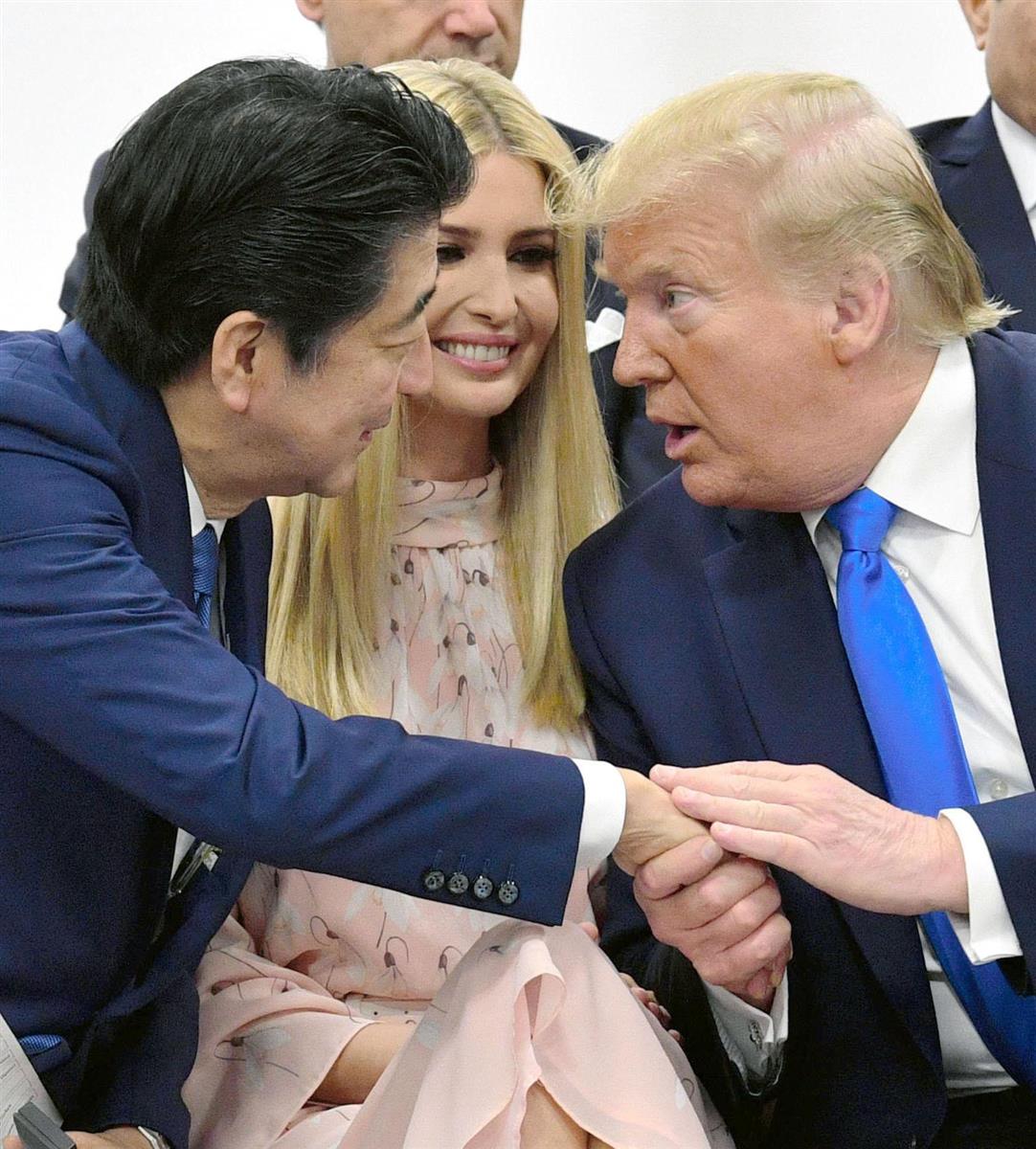昨年6月、大阪での20カ国・地域(G20)首脳会議(サミット)で行われた女性活躍推進のイベントに出席し、会話を交わす安倍晋三首相(左)とトランプ米大統領。中央はイバンカ大統領補佐官=大阪市