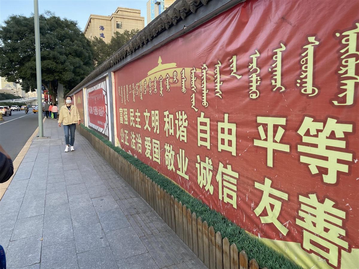 中国政府のスローガンが漢字とモンゴル文字で併記された看板。内モンゴル自治区では、中国語教育の強化で独自の文字や文化が失われかねないとの懸念が強まっている＝３日、フフホト市（三塚聖平撮影）