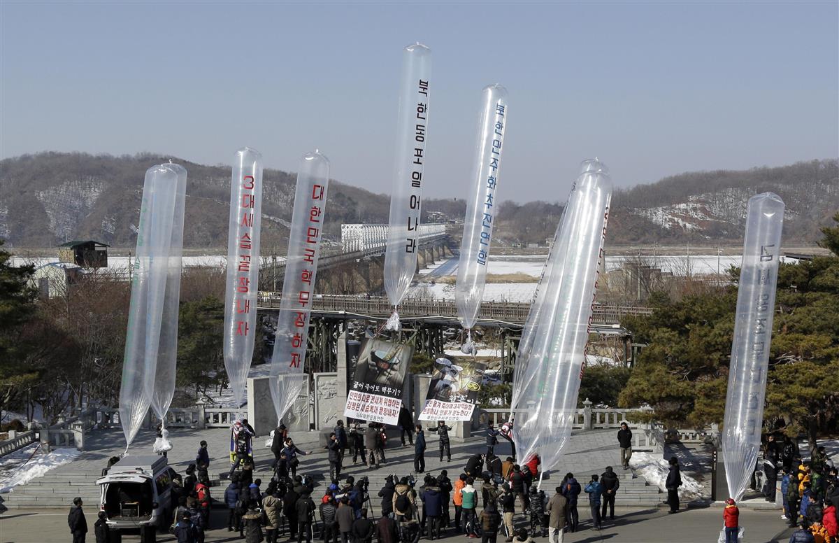 2013年、北朝鮮の体制を批判する宣伝ビラをつけた風船を北朝鮮に向けて飛ばす準備をする脱北者団体のメンバーら(AP)。これを禁止する法律が韓国国会で可決された