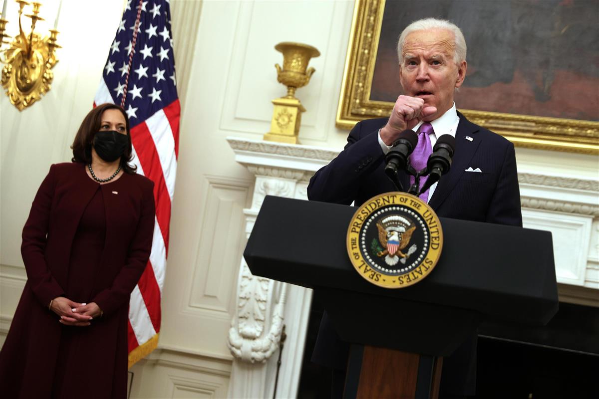 21日、米ホワイトハウスで、新型コロナウイルス対策について説明するバイデン大統領(右)=ワシントン(ゲッティ=共同)