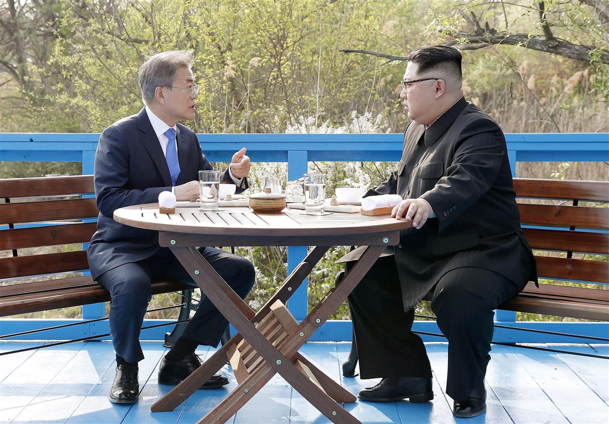 軍事境界線近くを散策中にベンチに座り、話をする韓国の文在寅大統領(左)と北朝鮮の金正恩朝鮮労働党委員長=板門店(韓国共同写真記者団・共同)