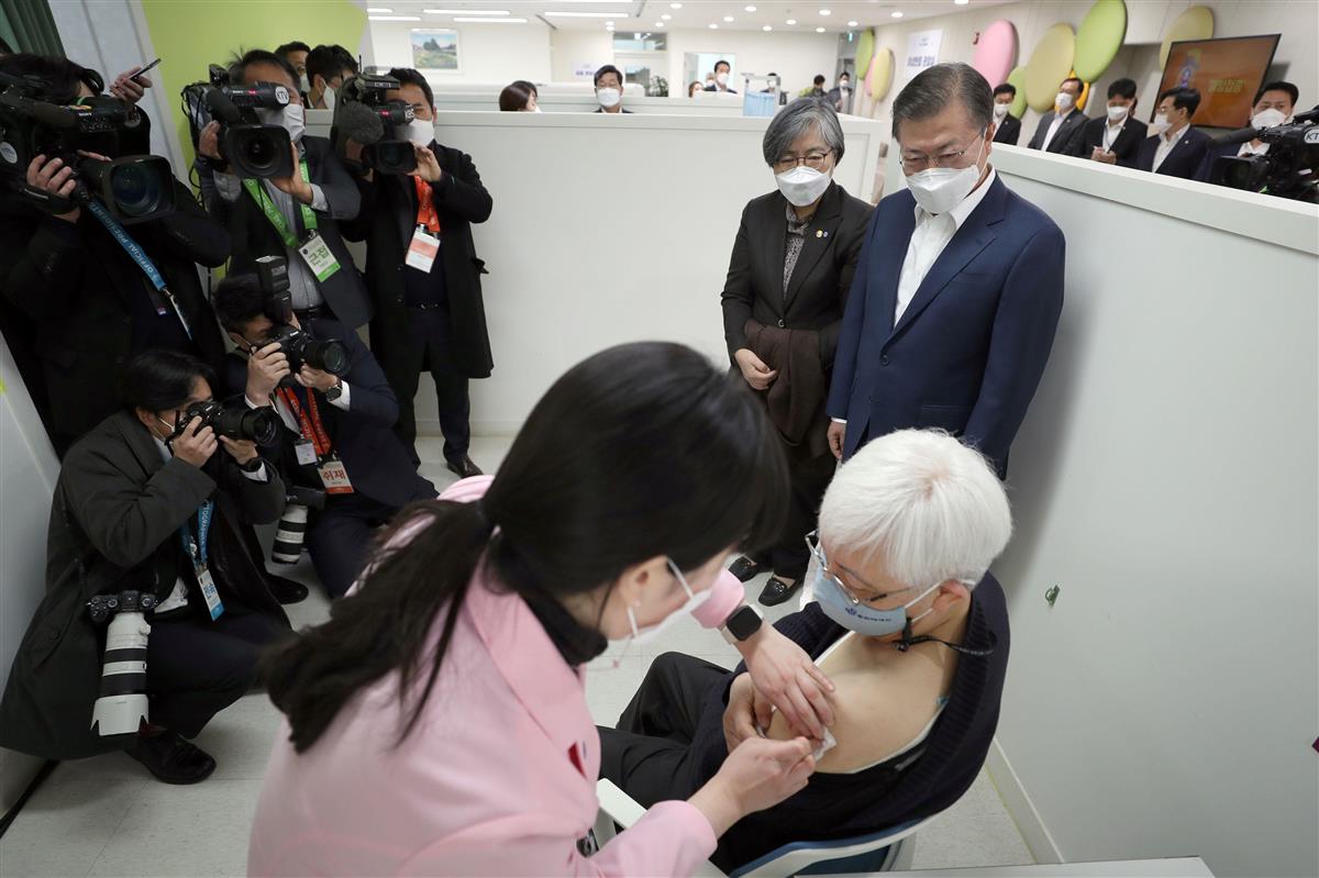 医師がアストラゼネカ製ワクチンを接種する様子を視察する韓国の文在寅大統領=2月26日、ソウル(ロイター)