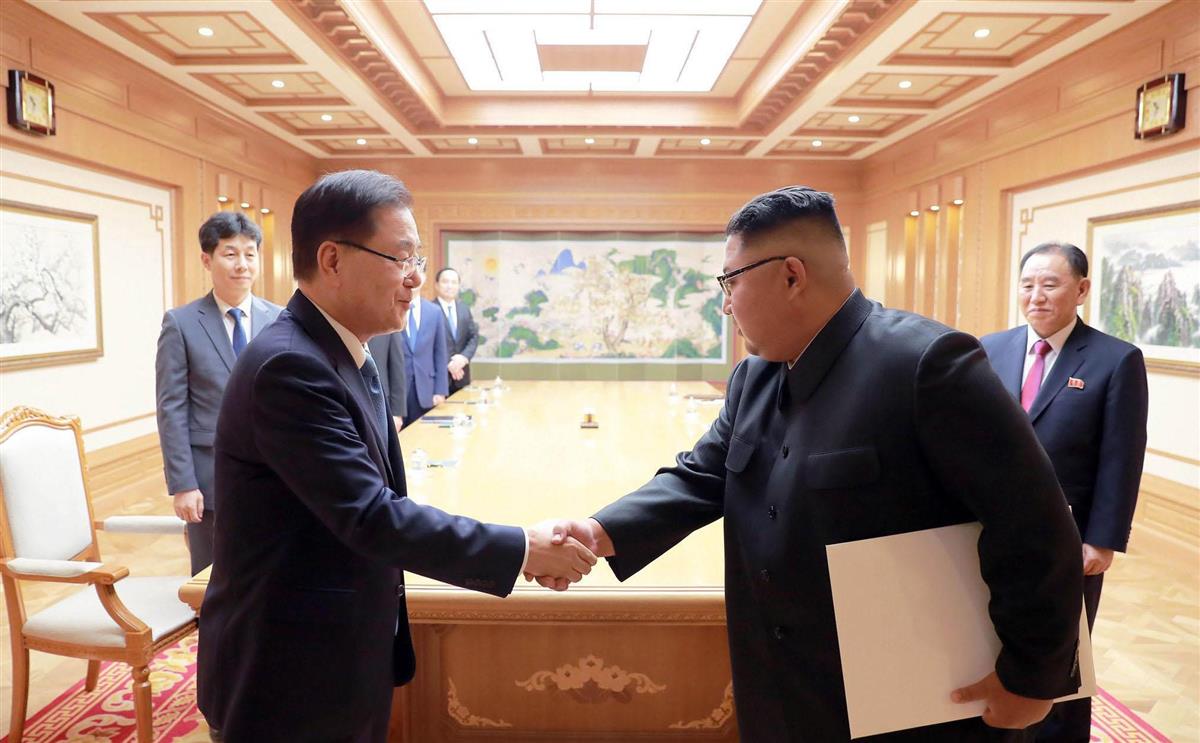 平壌の朝鮮労働党本部庁舎で、金正恩朝鮮労働党委員長(右、当時)と握手する韓国特使の鄭義溶氏=2018年9月(朝鮮通信=共同)