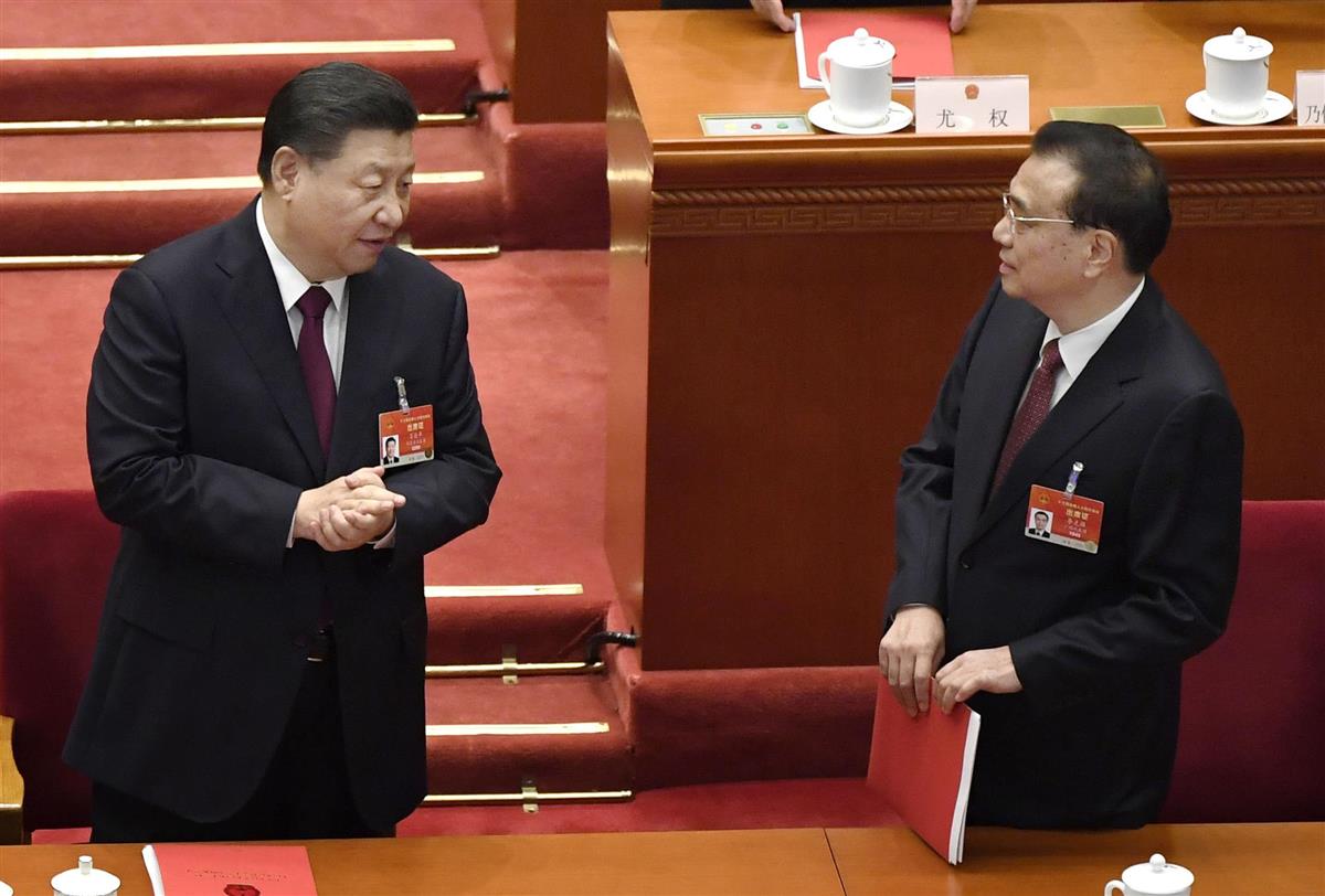 中国全人代の閉幕式を終え、李克強首相(右)と言葉を交わす習近平国家主席=11日、北京の人民大会堂(共同)
