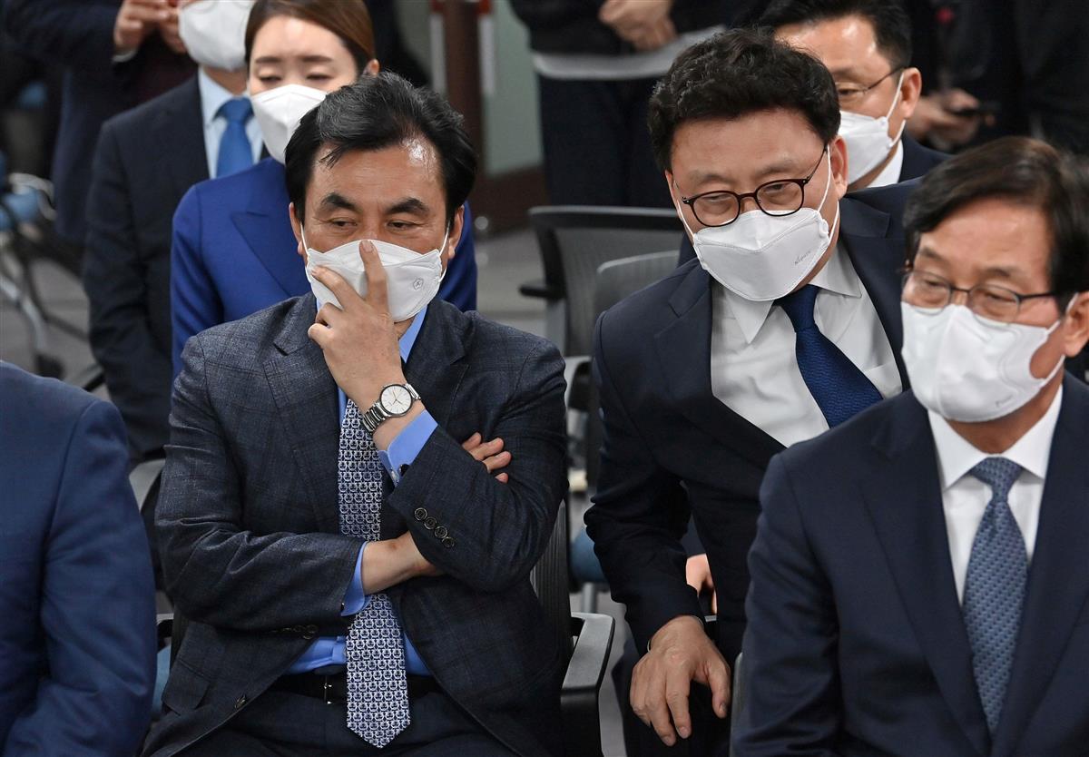 7日、ソウルで、ソウル市長選の出口調査報道を見て、表情を曇らせる与党「共に民主党」の人々(ロイター)