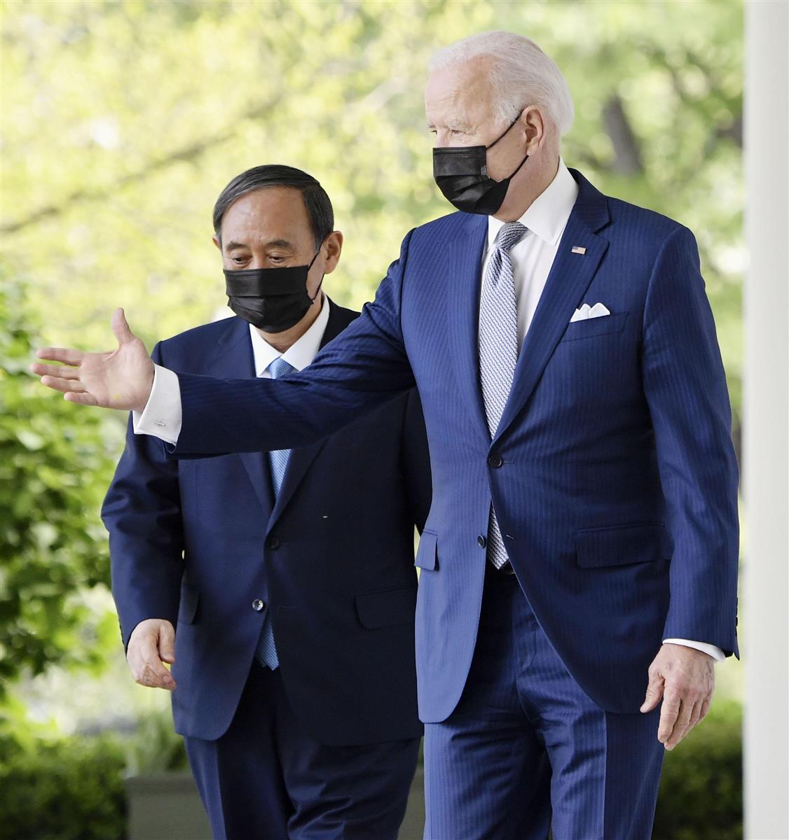 会談後、共同記者会見に向かうバイデン米大統領(右)と菅首相=16日、ワシントンのホワイトハウス(共同)